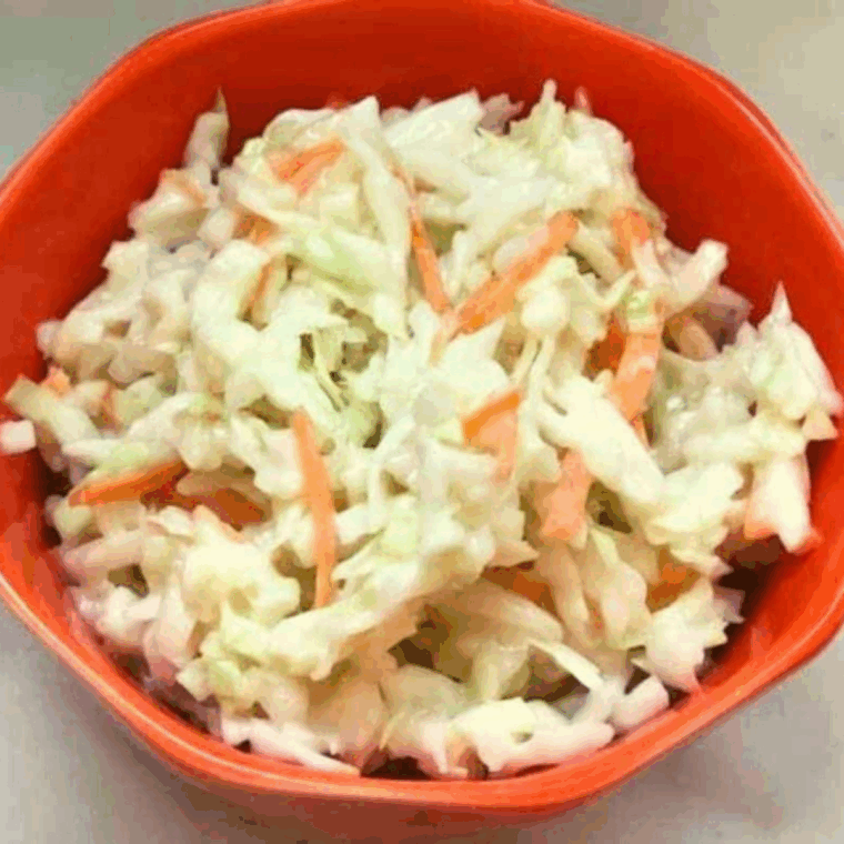 Homemade Cracker Barrel-style coleslaw in a white bowl with creamy dressing.