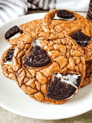 "Stack of fudgy Oreo brownie cookies topped with chunks of Oreo on a wire cooling rack"