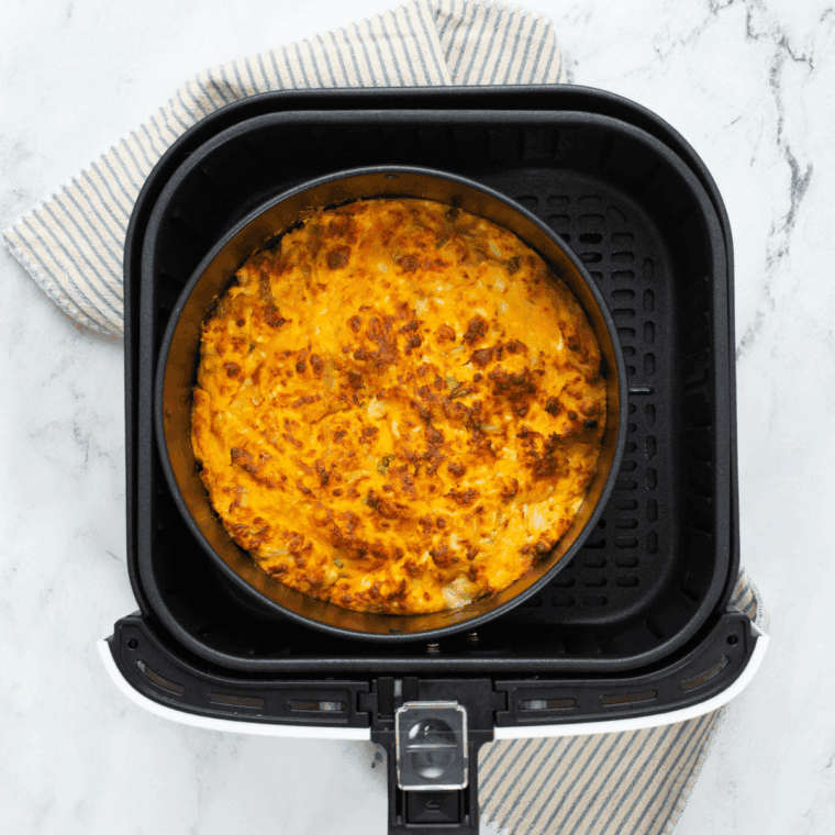 Air fryer buffalo chicken dip with bubbly melted cheese, topped with sliced green onions