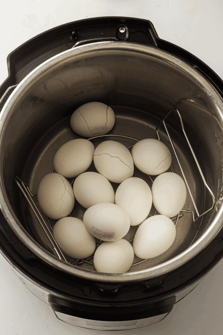 Instant Pot with no peel hard boiled eggs cooking on a trivet inside, showing perfectly cooked eggs ready to eat.