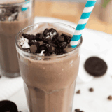 Glass filled with creamy Oreo shake topped with whipped cream and crushed Oreos, homemade Ninja Creami style.