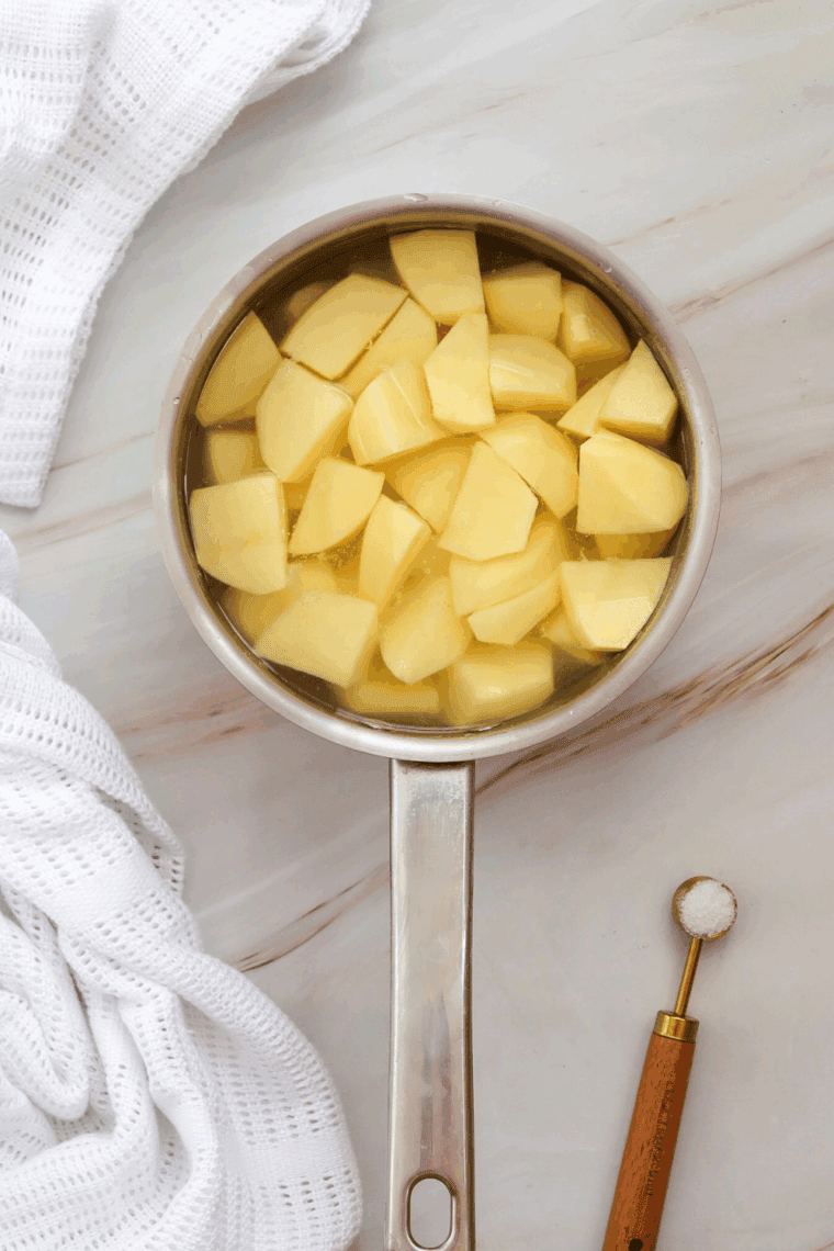 Boiling the potatoes in a small saucepan.