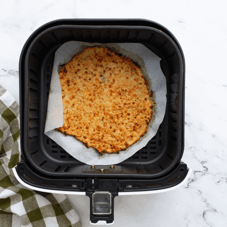 Topping air fryer chicken crust with marinara, cheese, and pepperoni before finishing cooking.
