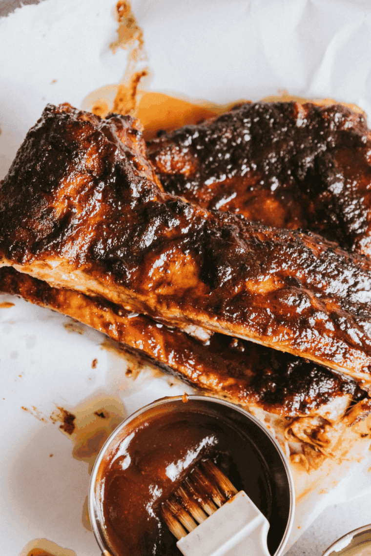 Homemade Applebee’s honey BBQ sauce in a bowl with brush for basting