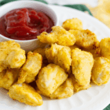 Homemade Arby’s Bronco Berry Sauce in a dipping bowl next to jalapeño poppers