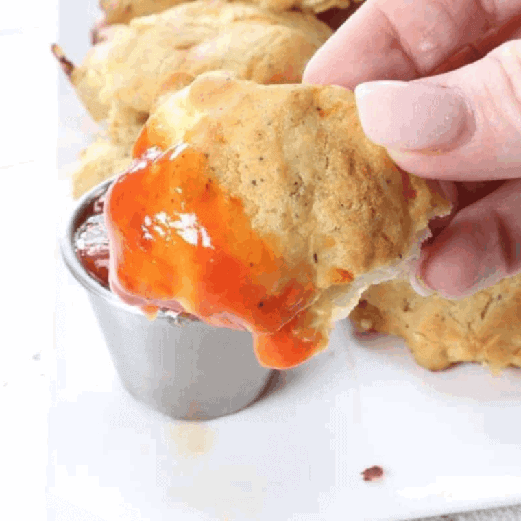 Chicken finger with sauce on top.