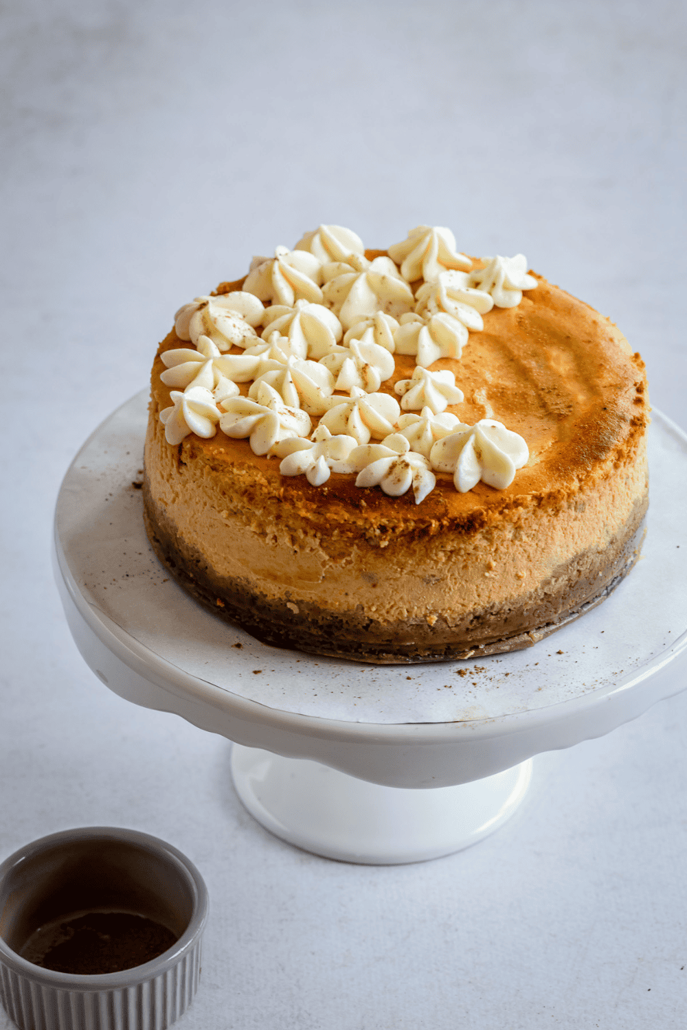 Close-up of a pumpkin cheesecake slice showing the creamy filling and graham cracker crust.