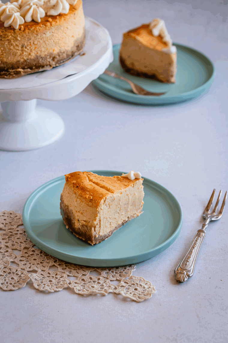 Whole pumpkin cheesecake topped with whipped cream and a dusting of fall spices.
