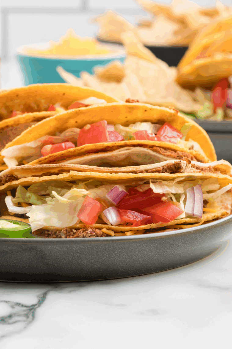 Homemade Double Decker Taco with seasoned ground beef, refried beans, melted cheese, lettuce, and crunchy taco shell wrapped in a soft flour tortilla.