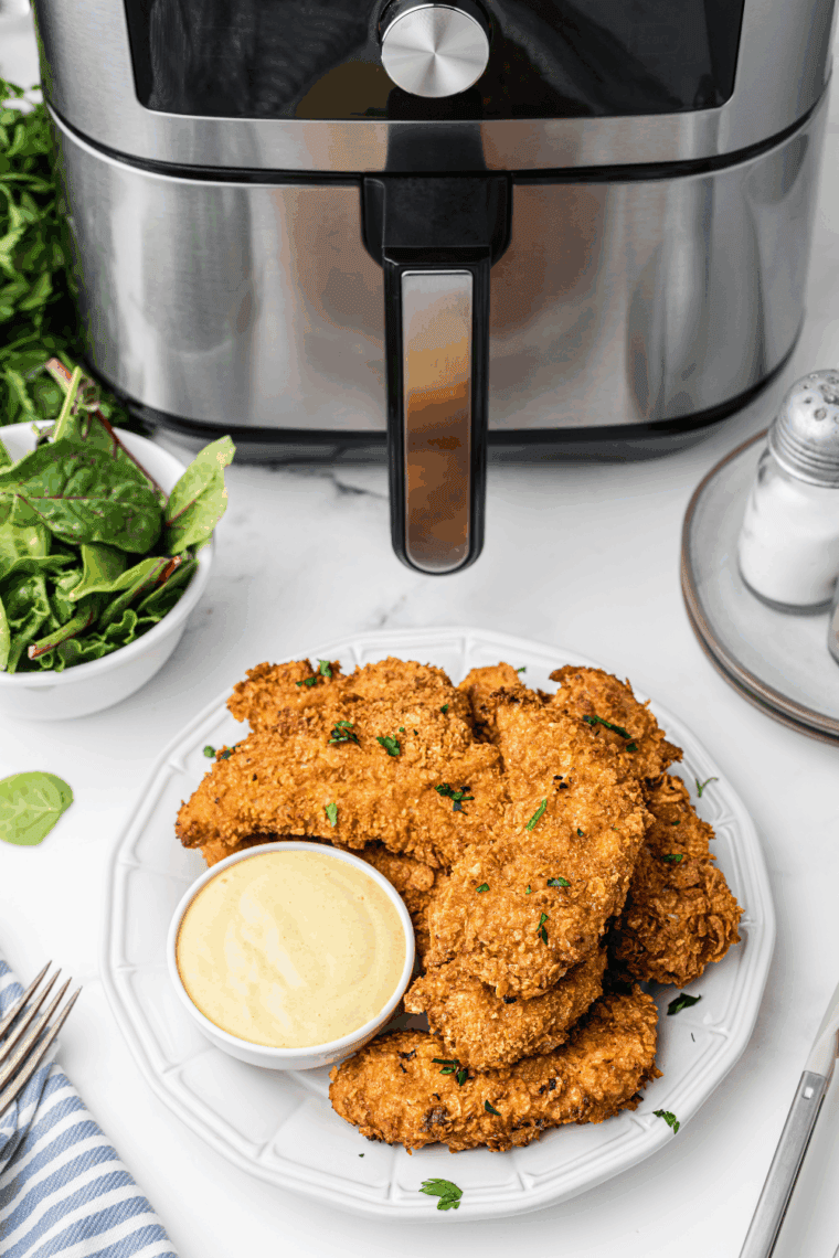 Bowl of Hardees Honey Mustard Recipe next to chicken tenders.