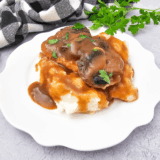 Bowl of homemade KFC copycat gravy served with mashed potatoes.
