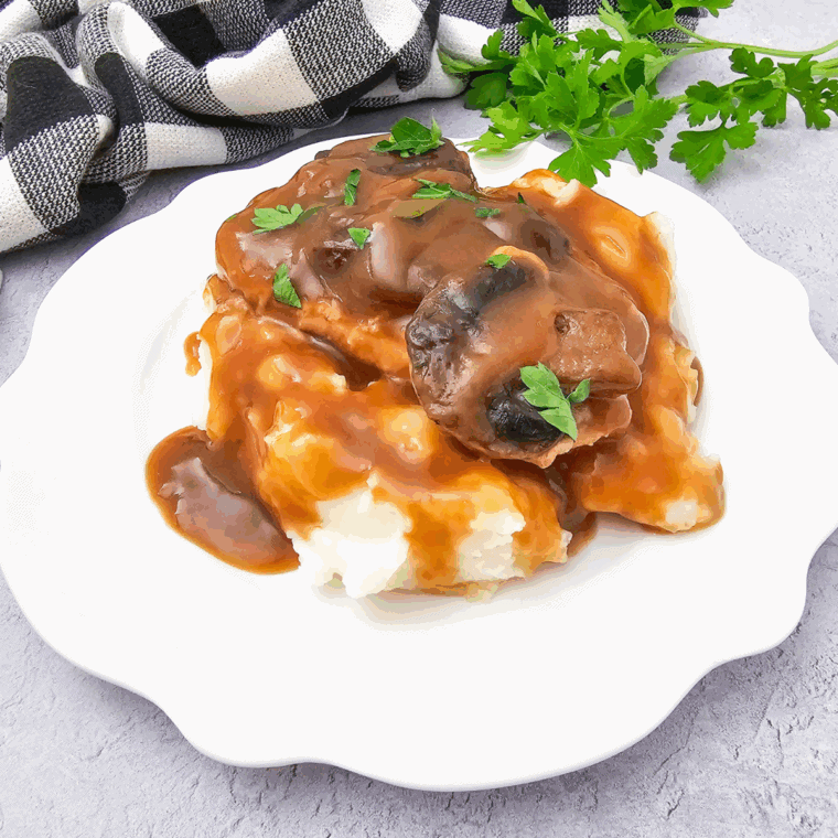 Bowl of homemade KFC copycat gravy served with mashed potatoes.