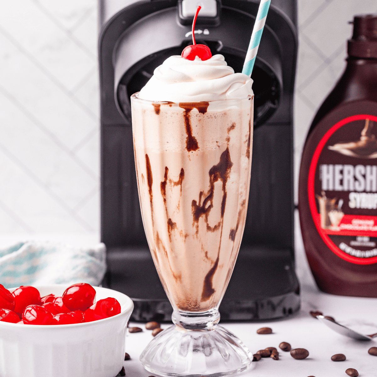 Glass of homemade Ninja Creami Jamocha Shake topped with whipped cream and chocolate drizzle