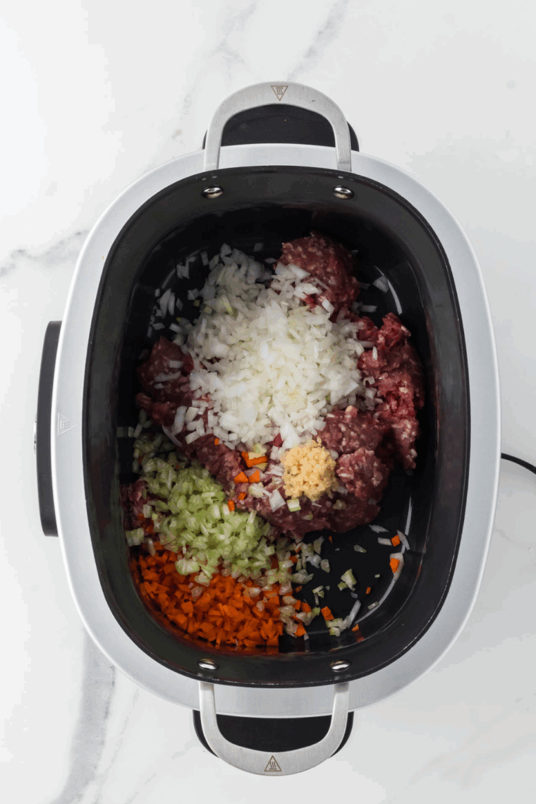 Sautéing diced onion, carrot, and celery in olive oil inside the Ninja Foodi Possible Cooker Pro.