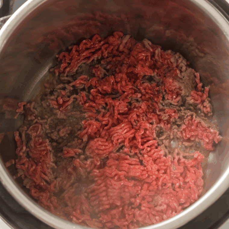 Sautéing diced onions, garlic, jalapeno, and browning ground beef in Instant Pot.