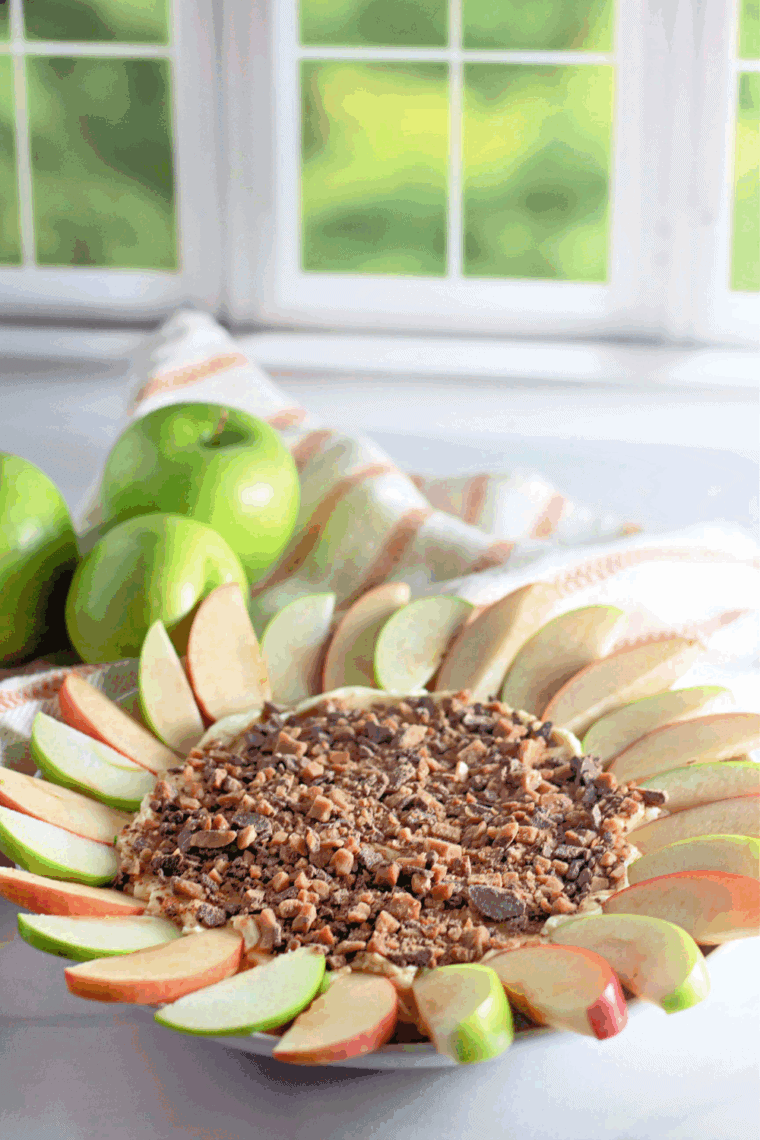 Creamy toffee apple dip topped with caramel sauce and Heath toffee bits, served with apple slices and graham crackers.