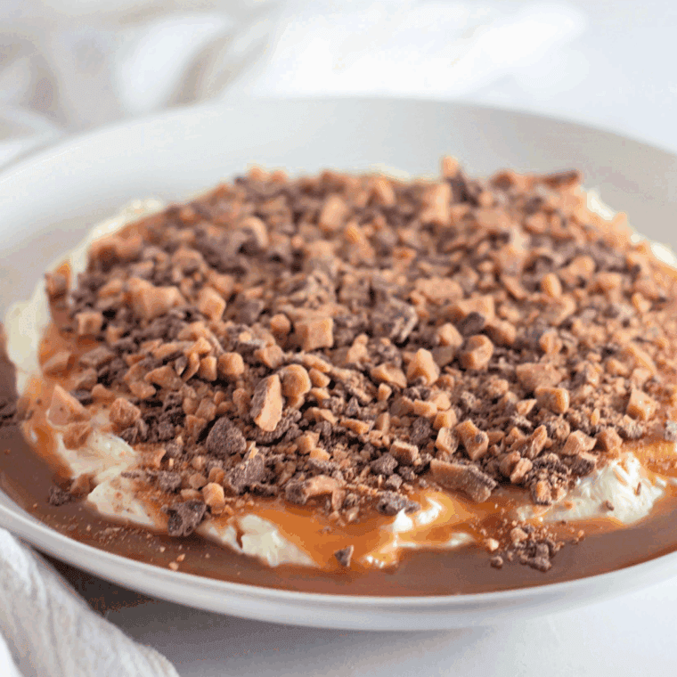 Creamy Toffee Apple Dip topped with caramel sauce and toffee bits served with fresh apple slices.