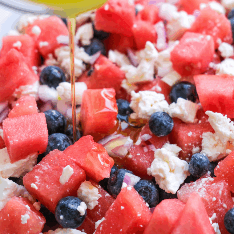Fresh watermelon feta salad with mint leaves in a white bowl, served as a light and colorful summer side dish.