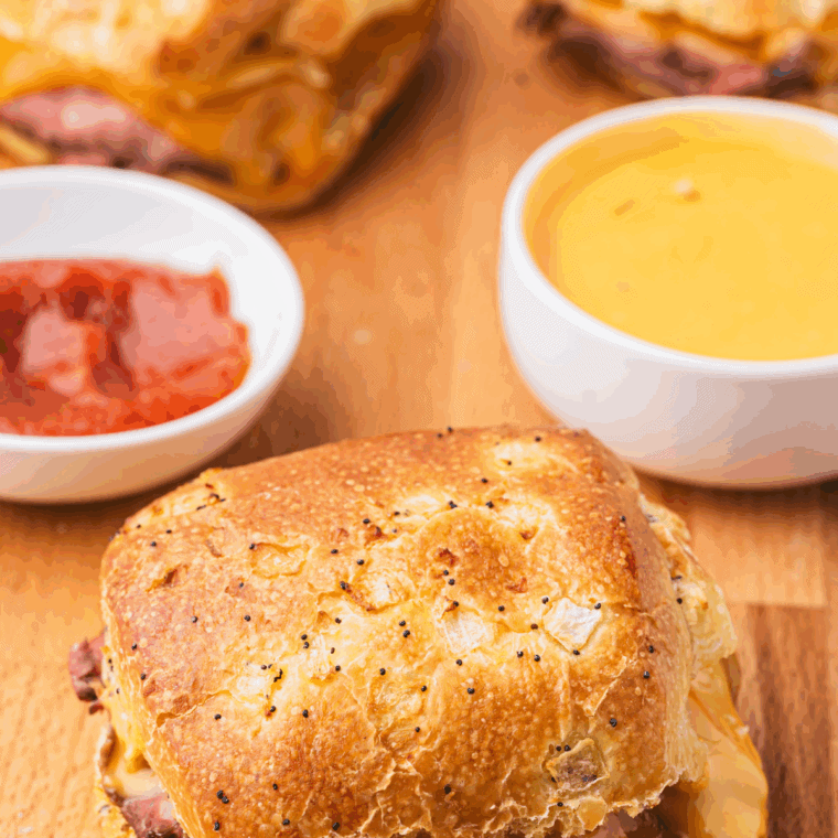 Thick and creamy Arby’s cheddar cheese sauce served in a bowl beside crispy fries.
