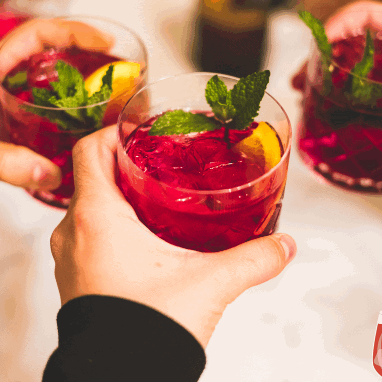Pitcher of Red Lobster-style sangria with fresh citrus slices and berries, served in a glass with ice.