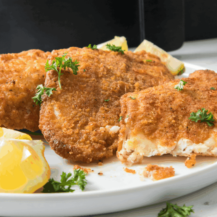 Crispy golden Captain D’s copycat catfish fillets on a plate with lemon wedges and tartar sauce.