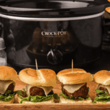 Tray of Cheesecake Factory-style meatball sliders with marinara and melted mozzarella on slider buns