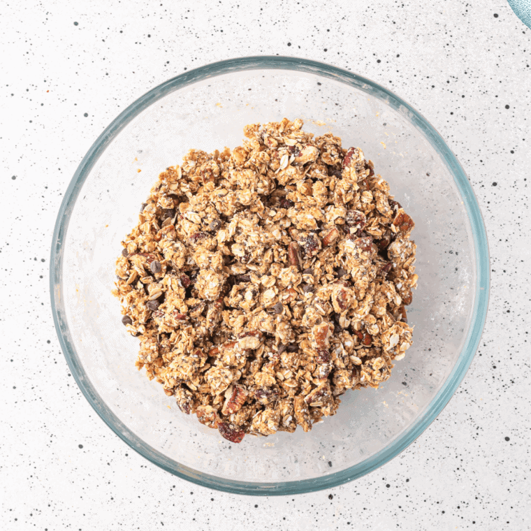 Stirring melted coconut oil, honey, and vanilla into oat mixture for granola clusters.