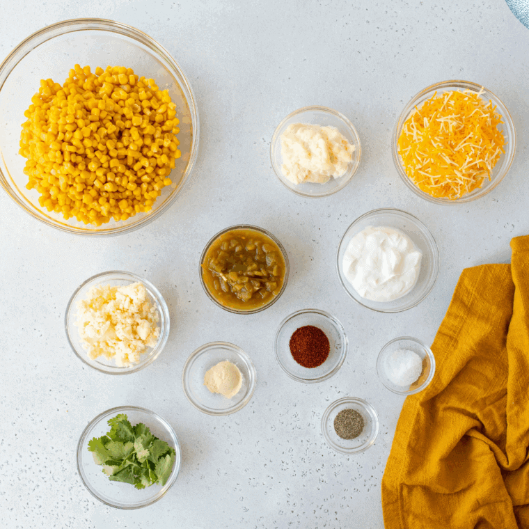 Ingredients for elote casserole — corn, mayonnaise, sour cream, cotija, lime, chili powder, and cilantro