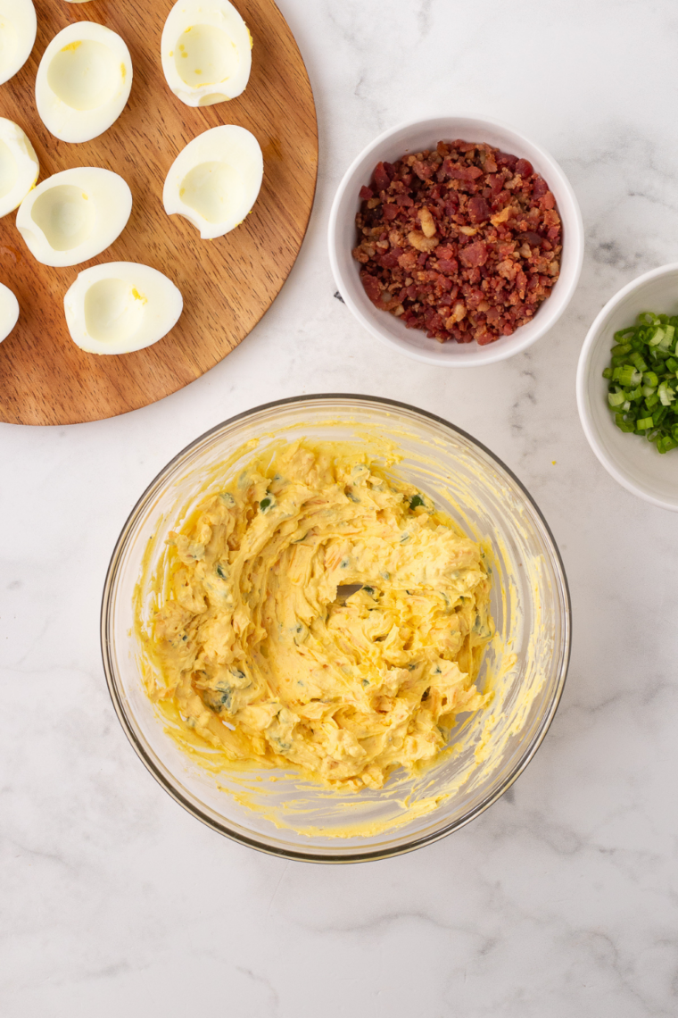 Hard-boiled eggs halved with yolks removed for deviled eggs