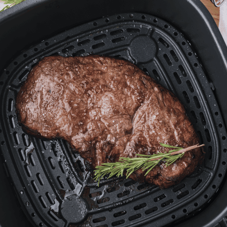 Juicy air fryer Longhorn Renegade Sirloin steak served with fresh herbs.