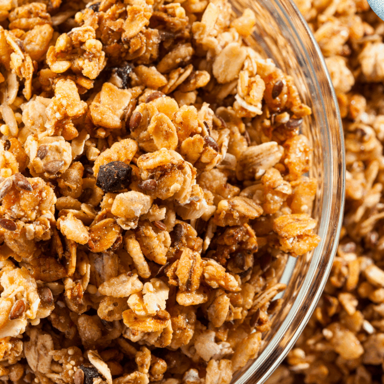 Bowl of golden homemade nut-free granola with oats, sunflower seeds, and dried cranberries