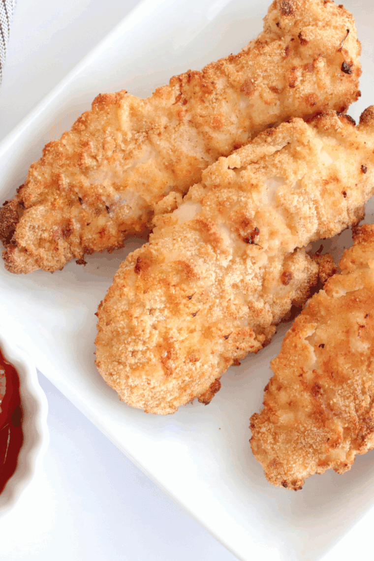 Homemade Dairy Queen-style chicken strips cooked in an air fryer, served on a plate with dipping sauce