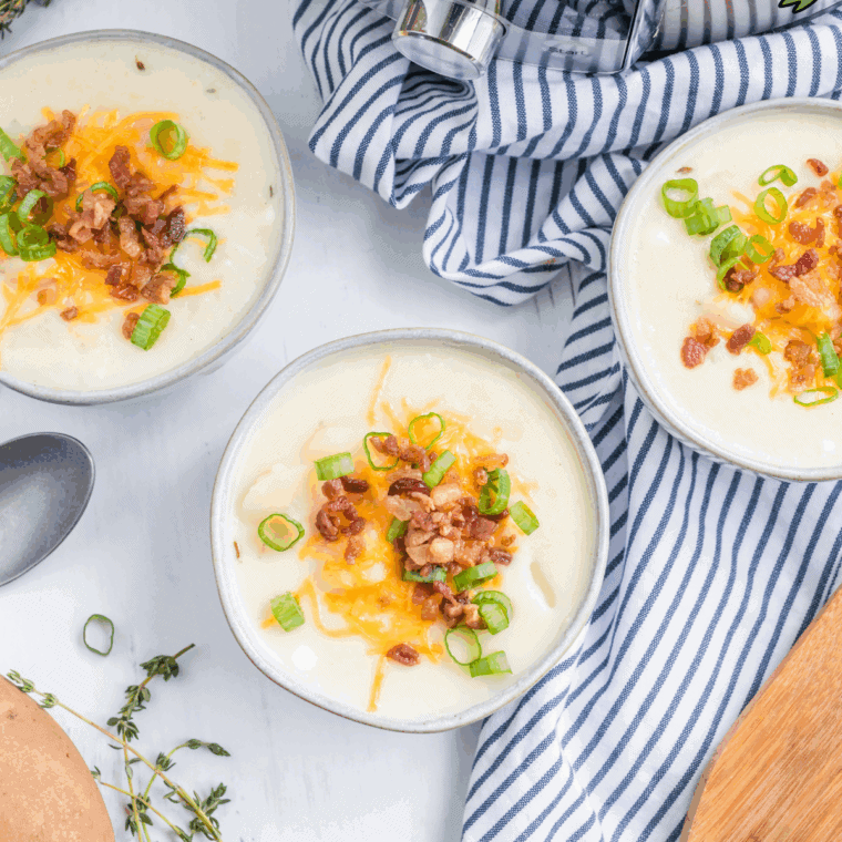 Bowl of creamy Copycat Jason’s Deli Irish Potato Soup garnished with fresh herbs.