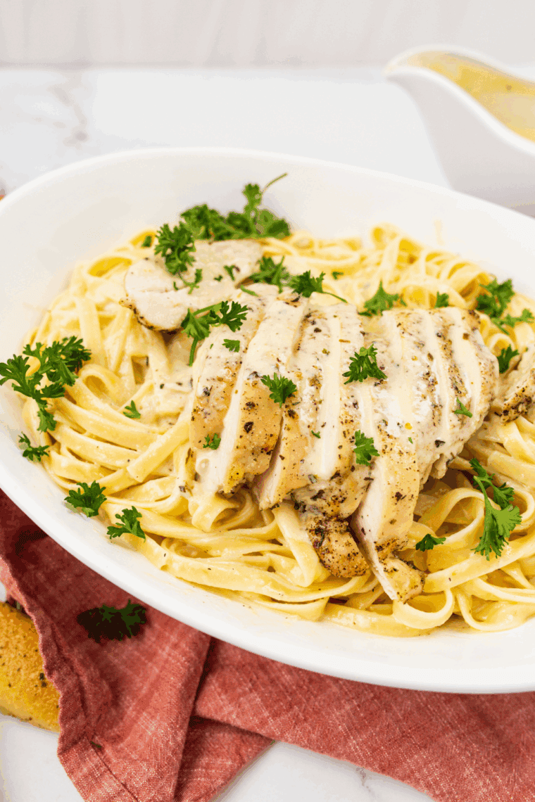 Domino’s-style chicken Alfredo pasta with creamy sauce, grilled chicken, Parmesan cheese, and parsley garnish.