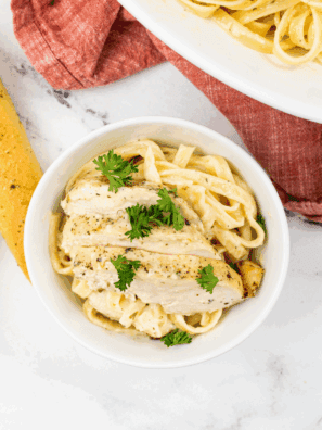 Homemade Domino’s-style chicken Alfredo pasta with creamy sauce, grilled chicken, and Parmesan, garnished with fresh parsley.
