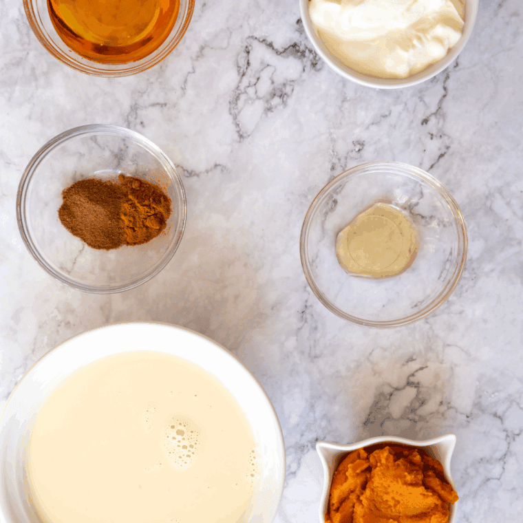 Ingredients needed for Ninja Creami Pumpkin Cheesecake Ice Cream on a kitchen table.