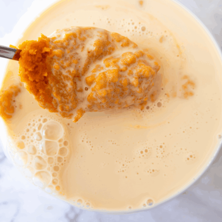 Pumpkin cheesecake ice cream base poured into a Ninja Creami pint container before freezing.