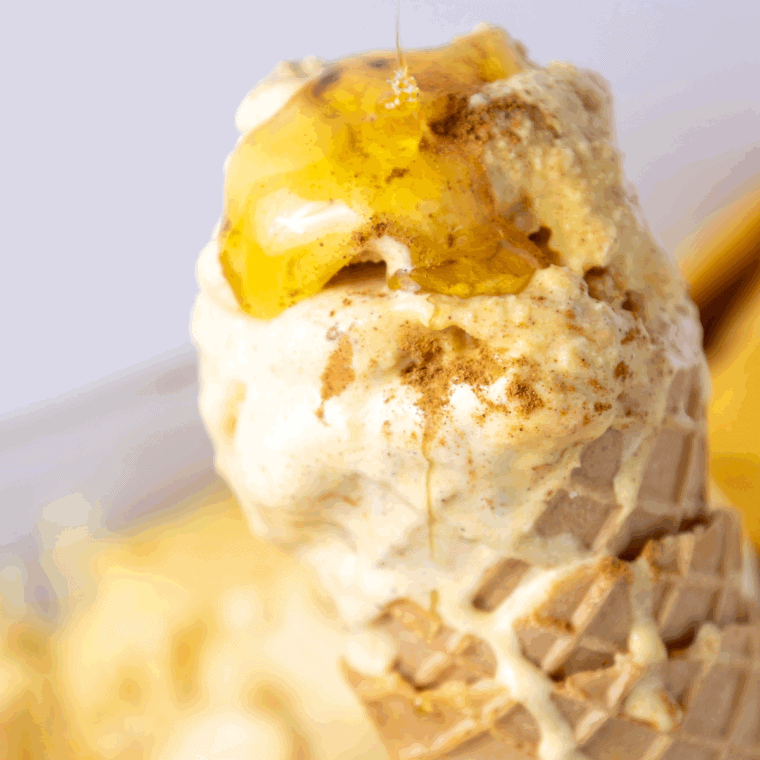 Ninja Creami Pumpkin Cheesecake Ice Cream served in a bowl, topped with whipped cream and a sprinkle of pumpkin spice.