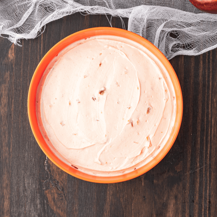 Onion dip smoothed into a round bowl to resemble a pumpkin shape.