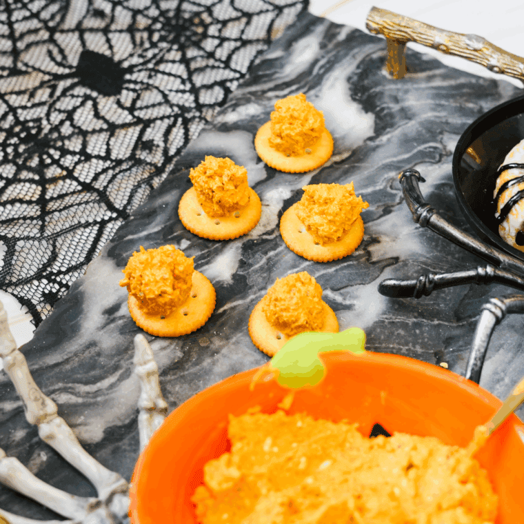Pretzel stick inserted into cheese ball as a pumpkin stem