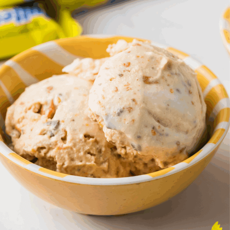 Finished Caramel Toffee Cookie Blizzard scooped in a bowl with caramel drizzle and cookie crumbles.