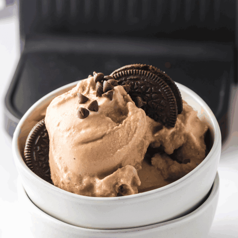 Scooping finished Cookies ‘n Cream ice cream into bowls or cones, optionally topping with extra cookie pieces or chocolate drizzle.