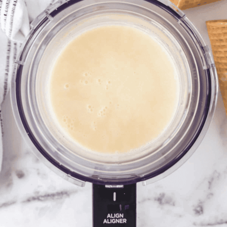 Pouring ice cream mixture into Ninja Creami pint container for freezing.