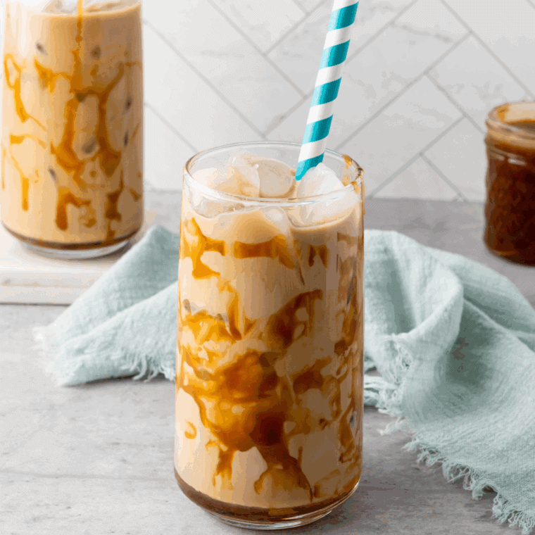 Glass of Tim Hortons iced coffee with ice cubes and milk swirl.
