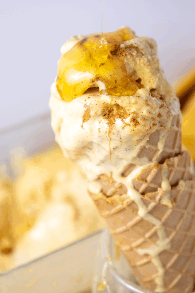 Easy Ninja Creami Pumpkin Cheesecake Ice Cream served in a bowl, topped with whipped cream and a sprinkle of pumpkin spice.