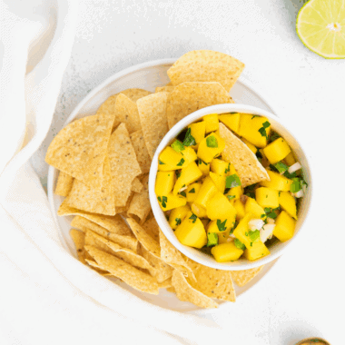 Bowl of vibrant mango salsa with diced mango, red bell pepper, jalapeño, and fresh herbs.