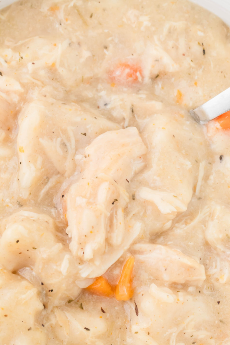Floured biscuit strips pressed into thickened creamy broth in a slow cooker to make dumplings.