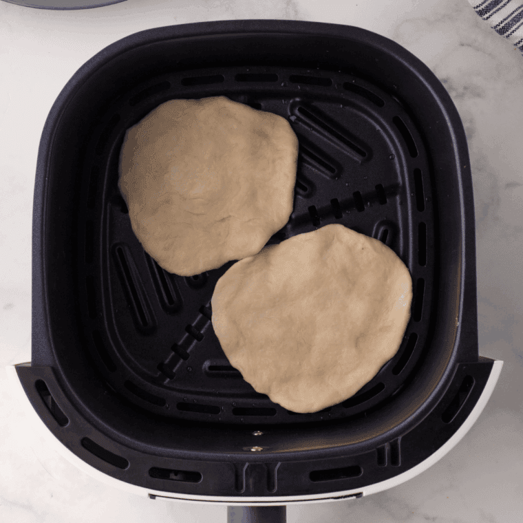 Stacking the freshly cooked tortillas and covering with a towel to keep them warm and soft.