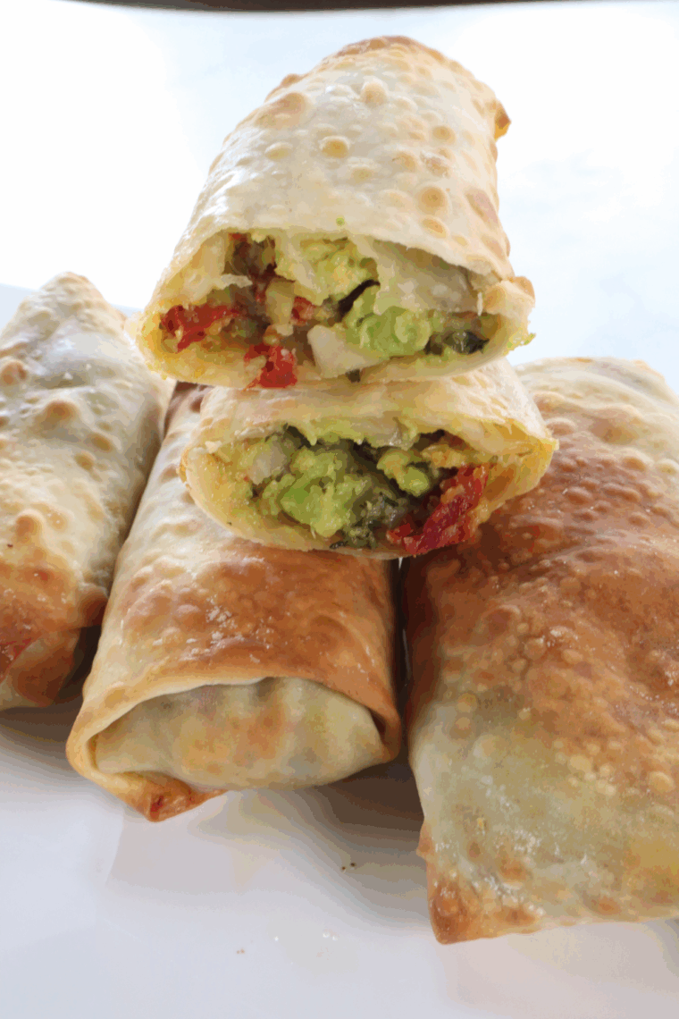 Plate of crispy BJ’s Avocado Egg Rolls with creamy cilantro-lime dipping sauce.