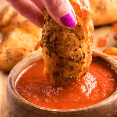 Bowl of easy calzone dipping sauce with herbs and tomato base